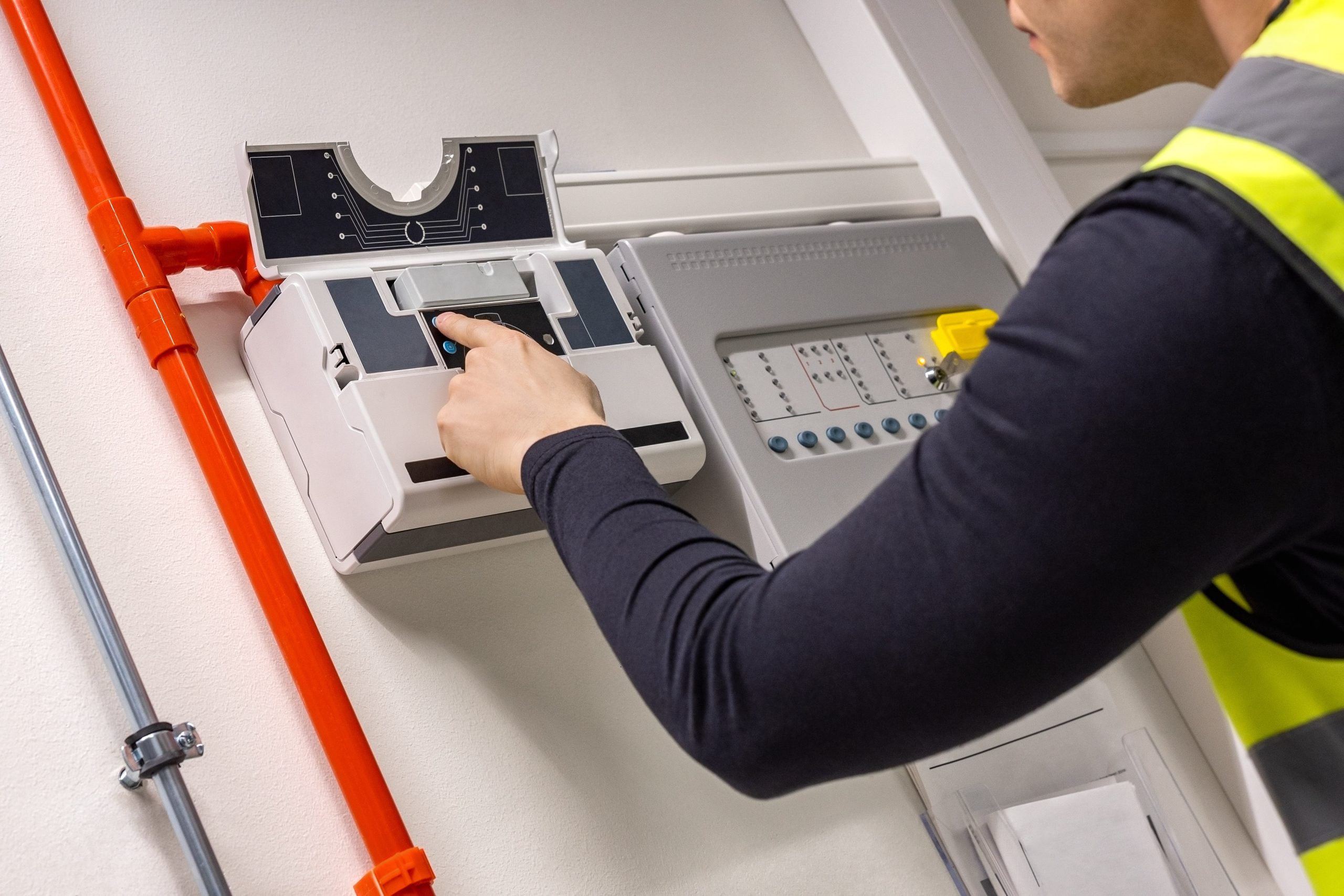 An engineer carrying out a fire risk assessment and checking on the fire panel